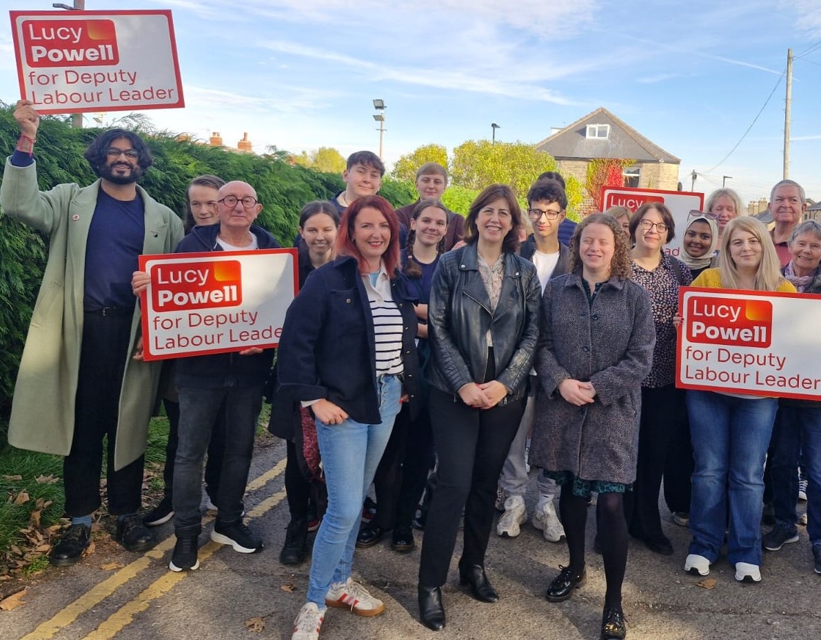 A group of Labour Party supporters surround MPs Lucy Powell, Louise Haigh and Olivia Blake. Some of them hold signs reading, "Lucy Powell For Deputy Labour Leader".
