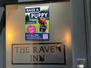 A poster of Support Dogs charity on the front door of The Raven Inn