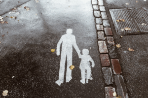 Man and a boy holding hands painted on the pavement in white paint