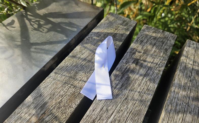 A white ribbon tied to a piece of wood