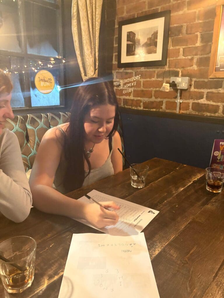 Quiz attendee writing quiz answers on answer sheet