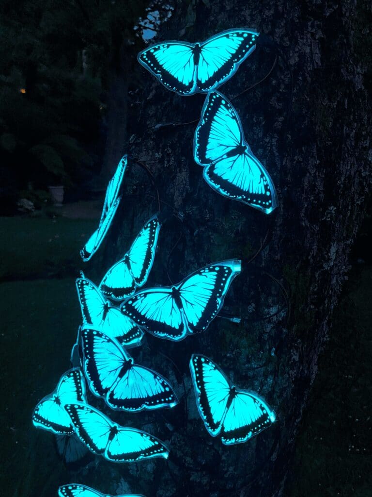 Fluorescent blue butterflies on a tree.