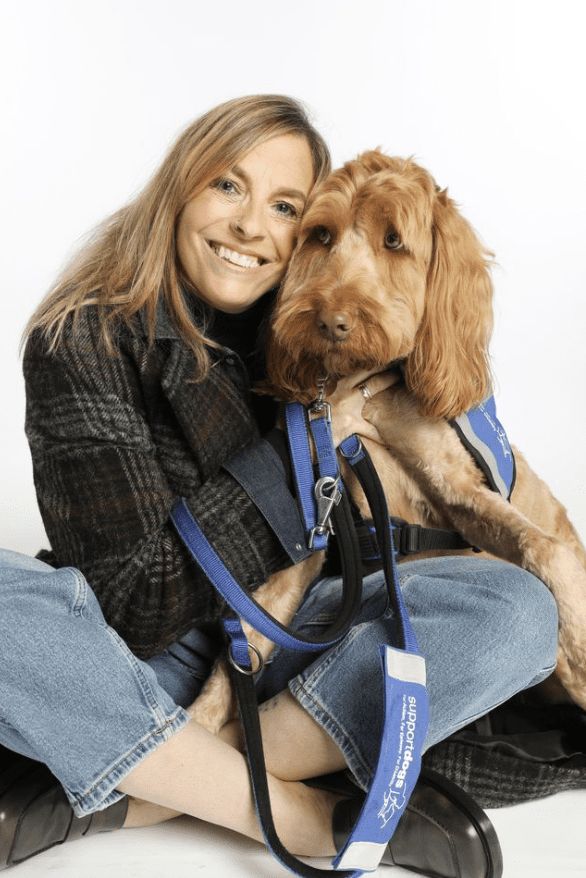 women sitting on floor huggin brown dog 
