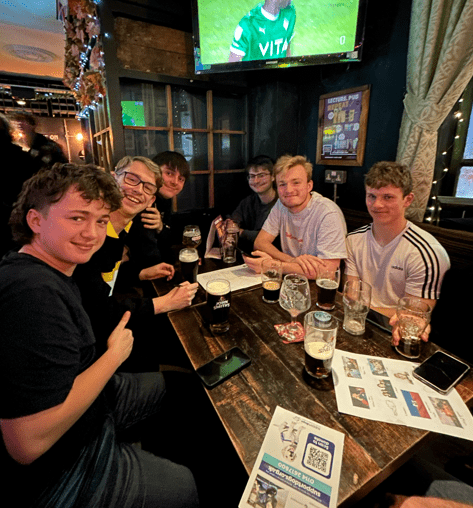 Group of people at sat down at a pub quiz