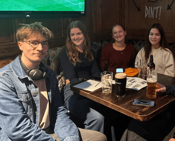 Group of people at sat down at a pub quiz