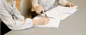 two women signing a work contract