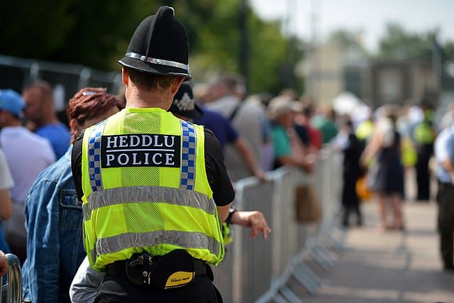 A policeman observing a crowd in Wales