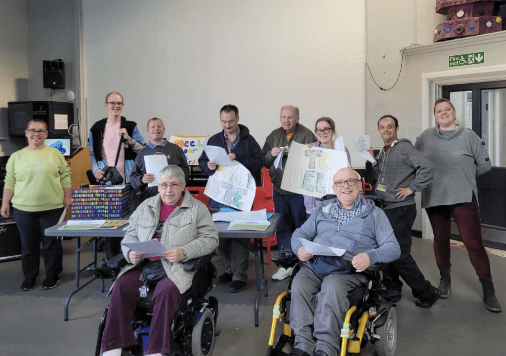 group of people, two in wheelchairs, smiling for picture
