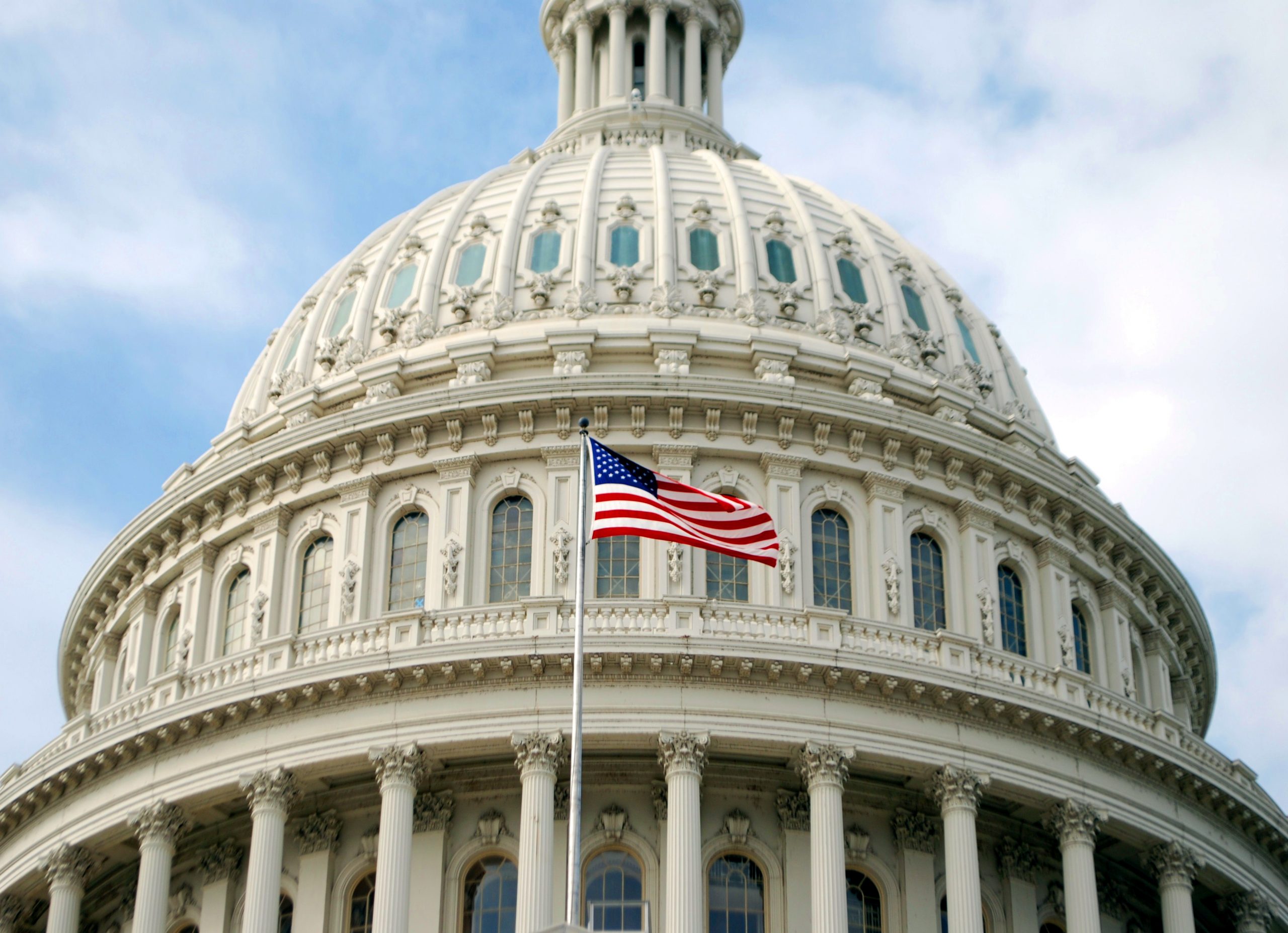 An American flag flying in front of the United States Capitol, Washington, D.C.