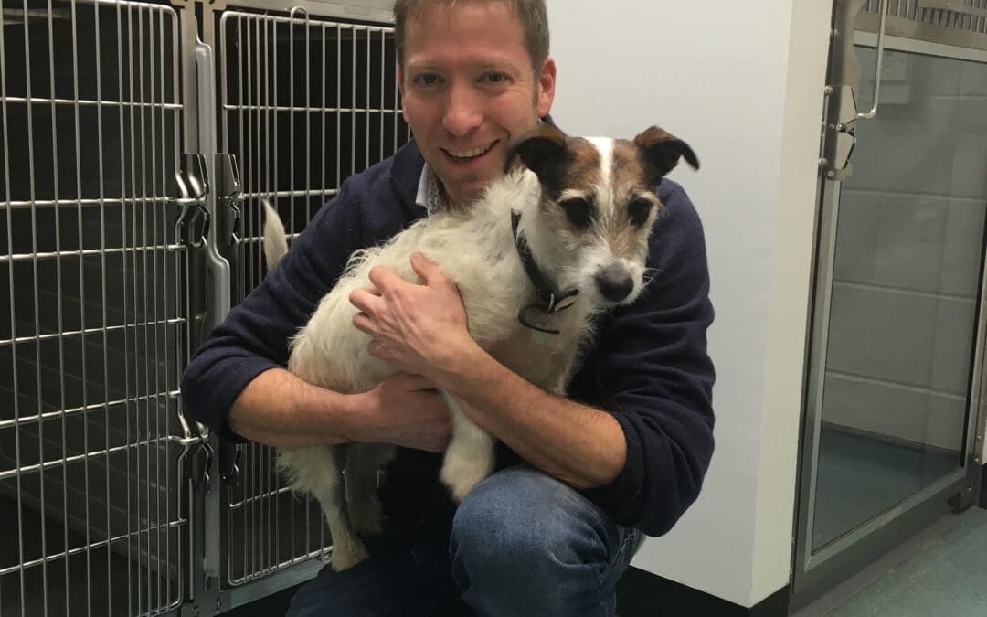 Julian Norton, Yorkshire Vet, holding a Jack Russell and smiling
